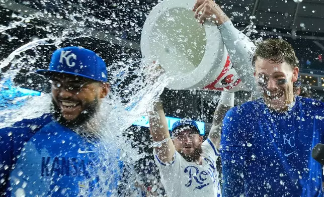 Kansas City Royals' Carlos Duran, left, and Bobby Witt Jr., right, are doused by Kyle Isbel, center, after their baseball game against the Athletics, Tuesday, Aug. 18, 2026, in Kansas City, Mo. (AP Photo/Charlie Riedel)