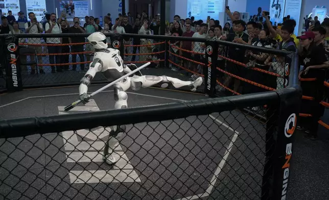 Visitors watch a humanoid robot perform during the World Robot Conference at the Beiren Yichuang International Convention and Exhibition Centre in Beijing, Wednesday, Aug. 19, 2026. (AP Photo/Andy Wong)