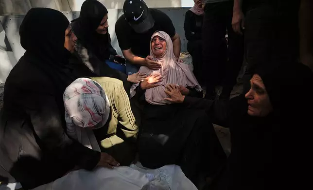Mourners attend the funeral of Palestinians who were killed in an Israeli army strike on a cafe at the Gaza port the previous day, at Shifa Hospital in Gaza City, Wednesday, Aug. 19, 2026. (AP Photo/Jehad Alshrafi)