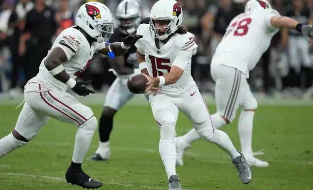 Arizona Cardinals quarterback Gardner Minshew II (15) hands the ball off to Cardinals running back Jeremiyah Love (4) during the first half of a preseason NFL football game, Thursday, Aug. 13, 2026, in Las Vegas. (AP Photo/John Locher)