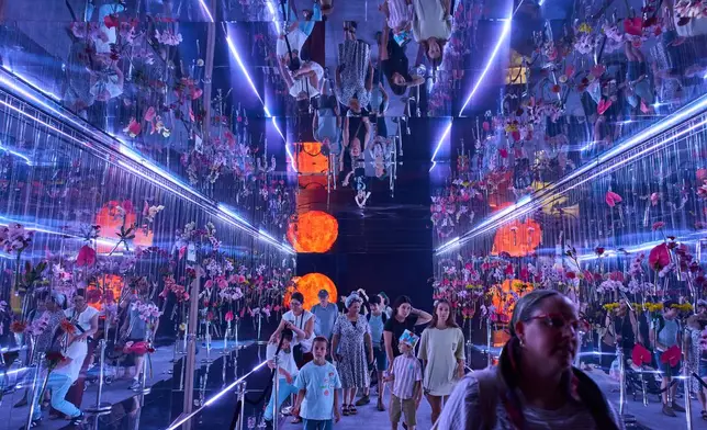 People visit the flower exhibition in Tel Aviv, Israel, Thursday, Aug. 13, 2026. (AP Photo/Oded Balilty)