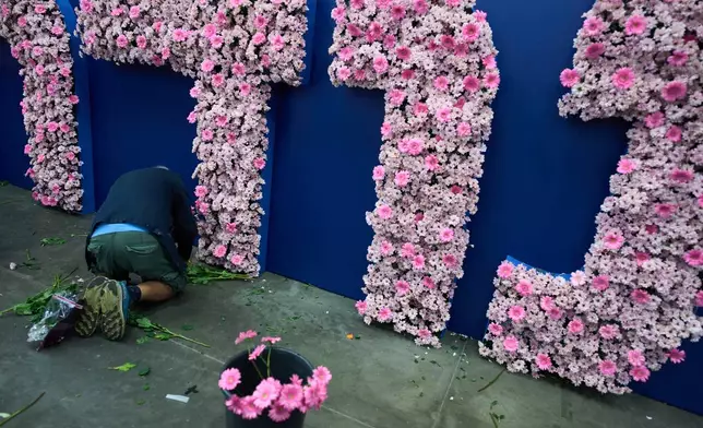 A worker arranges flowers in preparation for the flower exhibition in Tel Aviv, Israel, Wednesday, Aug. 12, 2026. (AP Photo/Oded Balilty)