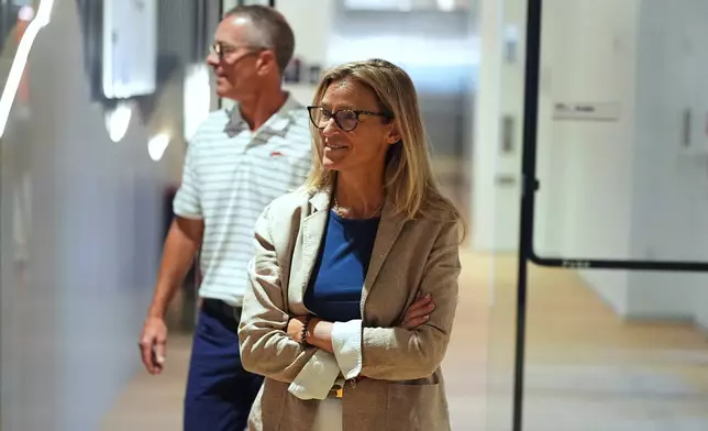 Denver Broncos co-owner Carrie Walton Penner, front, and her husband, team co-owner and chief executive officer Greg Penner arrive to talk to reporters at the team's NFL football training camp in Centennial, Colo., Tuesday, Aug. 11, 2026. (AP Photo/David Zalubowski)