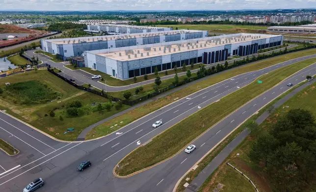 FILE - Cars drive past data centers, July 16, 2023, in Ashburn, Va. (AP Photo/Ted Shaffrey, File)