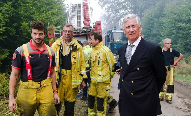 Belgium's King Philippe, right, meets firefighters as a wildfire burns in Waimes, Belgium, Monday, Aug. 17, 2026. (Nicolas Lambert, Pool Photo via AP)