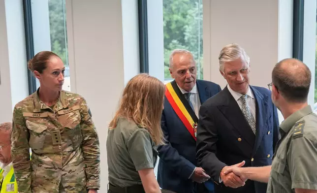 Belgium's King Philippe, second right, and Governor of Liege Province Herve Jamar, center, meet with emergency teams and volunteers involved in fighting a wildfire in Vottem, Belgium, Monday, Aug. 17, 2026. (Photo AP/Marius Burgelman)