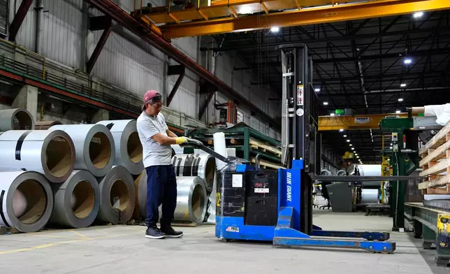 A worker operates a forklift in front of steel coils at the manufacturing plant of Ideal Roofing in Ottawa on Tuesday, Aug. 25, 2026. (Justin Tang/The Canadian Press via AP)