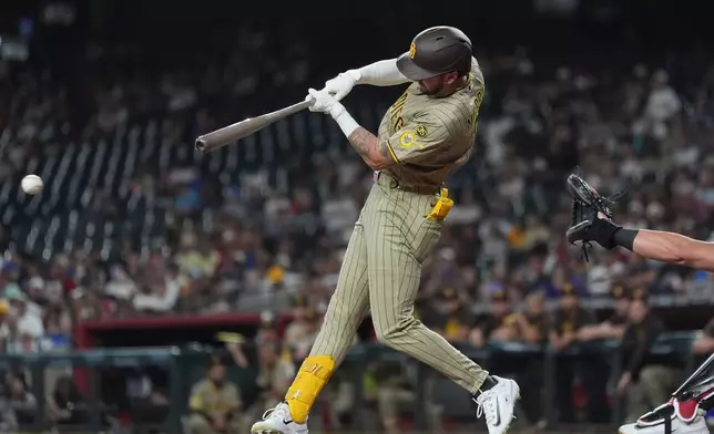 San Diego Padres' Jackson Merrill connects for an infield single against the Arizona Diamondbacks during the second inning of a baseball game, Monday, Aug. 3, 2026, in Phoenix. (AP Photo/Ross D. Franklin)