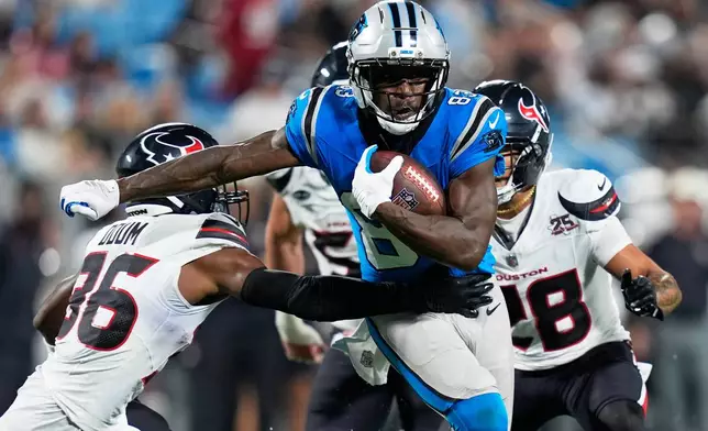 Carolina Panthers wide receiver David Moore runs around Houston Texans' George Odom during the first half of an NFL preseason football game, Friday, Aug. 28, 2026, in Charlotte, N.C. (AP Photo/Erik Verduzco)
