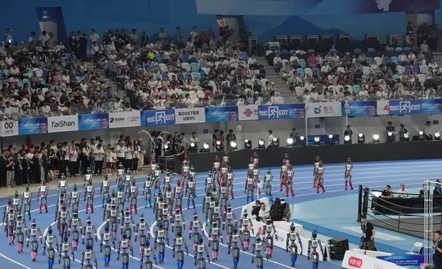 Robots walk during the opening ceremony of the World Humanoid Robot Games in Beijing, Saturday, Aug. 22, 2026. (AP Photo/Achmad Ibrahim)
