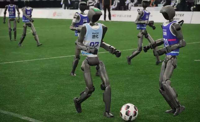 Humanoid robots are playing soccer ahead the opening ceremony of the World Humanoid Robot Games in Beijing, Saturday, Aug. 22, 2026. (AP Photo/Achmad Ibrahim)