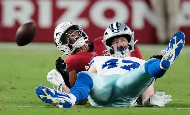 Dallas Cowboys tight end Zack Kuntz (47) takes a hit from Arizona Cardinals safety Dadrion Taylor-Demerson, rear, in the first half of a preseason NFL football game Saturday, Aug. 22, 2026, in Glendale, Ariz. (AP Photo/Ross D. Franklin)