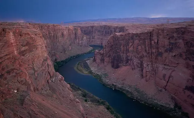 FILE - The Colorado River flows near the Glen Canyon Dam, July 15, 2026, near Page, Ariz. (AP Photo/John Locher, File)