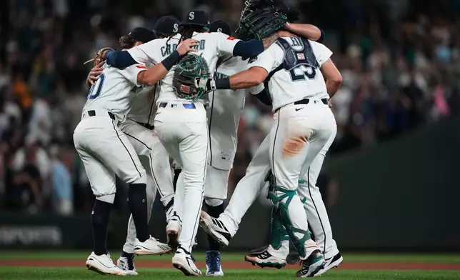 The Seattle Mariners infield, including shortstop J.P. Crawford (3) and catcher Cal Raleigh (29) celebrate a win over the Philadelphia Phillies in a baseball game, Tuesday, Aug. 25, 2026, in Seattle. (AP Photo/Lindsey Wasson)