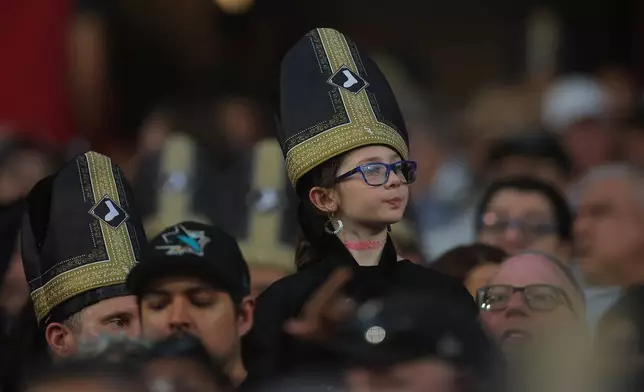 A fan wears a promotional pope hat during a baseball game between the Cincinnati Reds and Chicago White Sox, Tuesday, Aug. 11, 2026, in Chicago. (AP Photo/Melissa Tamez)