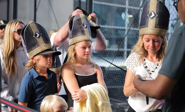 A group of fans wore a promotional Pope hat prior to a baseball game between the Cincinnati Reds and Chicago White Sox, Tuesday, Aug. 11, 2026, in Chicago. (AP Photo/Melissa Tamez)