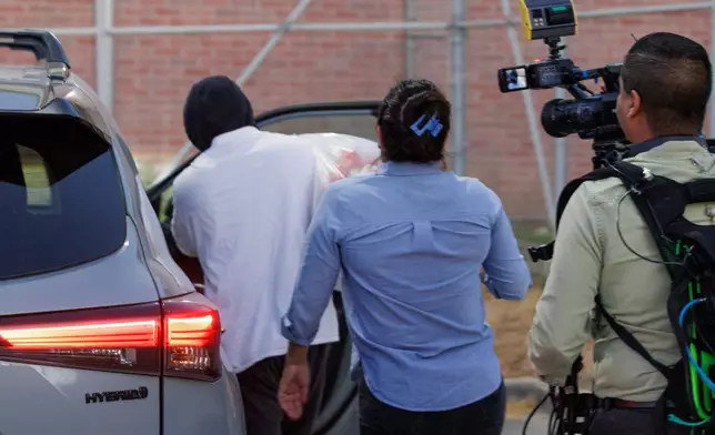 Immigration and Customs Enforcement officer Christian Castro gets into a car surrounded by news reporters moments after being released from the Carrizalez-Rucker Cameron County Detention Center in Brownsville, Texas on Thursday, Aug. 27, 2026. (AP Photo/Michael Gonzalez)