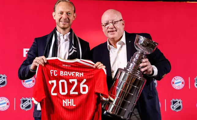 Rouven Kasper, left, chief marketing and sales officer for FC Bayern Munich AG, and Bill Daly, deputy commissioner of the NHL, pose during a joint press conference by FC Bayern Munich and the National Hockey League, Thursday, Aug. 20, 2026, in Munich. (Matthias Balk/dpa via AP)