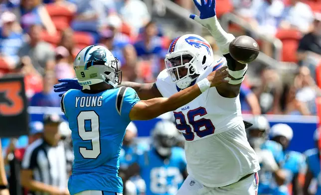 Carolina Panthers quarterback Bryce Young (9) passes around Buffalo Bills defensive tackle Deone Walker (96) during the first half of a preseason NFL football game, Saturday, Aug. 15, 2026, in Orchard Park, N.Y. (AP Photo/Adrian Kraus)