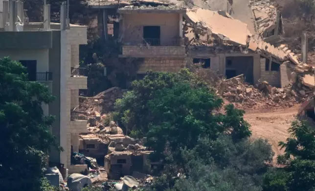 Israeli military vehicles, left, are seen stationed among homes in the village of Zawtar al-Sharqiyah, occupied by Israeli forces, is seen from the southern village of Zawtar al-Gharbieh, Lebanon, Wednesday, Aug. 5, 2026. (AP Photo/Mohammed Zaatari)