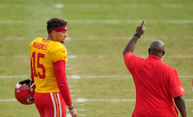 Kansas City Chiefs quarterback Patrick Mahomes (15) talks with offensive coordinator Eric Bieniemy during NFL football training camp Tuesday, Aug. 11, 2026, in St. Joseph, Mo. (AP Photo/Charlie Riedel)