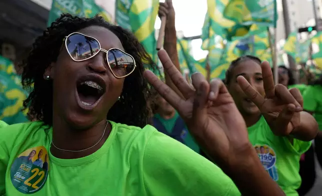 Supporters of opposition presidential candidate Flavio Bolsonaro attend a campaign motorcade in the Duque de Caxias neighborhood of Rio de Janeiro, Brazil, Friday, Aug. 21, 2026. (AP Photo/Silvia Izquierdo)