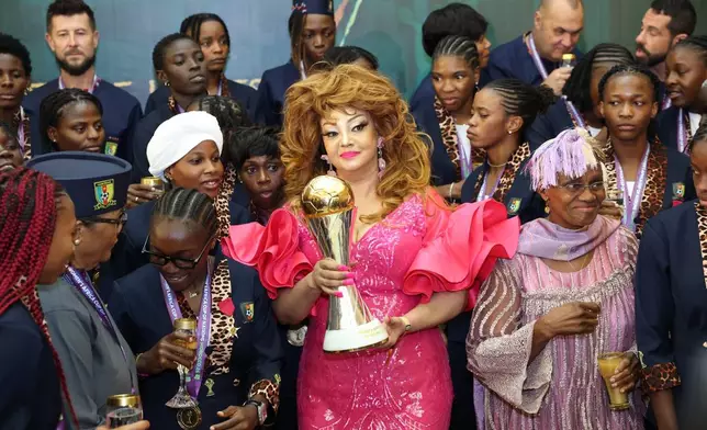 Cameroon's First Lady, Chantal Biya, poses for a photograph with the Women Africa Cup of Nations trophy and Cameroon female soccer team players during a reception at the Unity Palace in Yaounde, Cameroon. Saturday, Aug. 22, 2026. (AP Photo/Angel Ngwe)