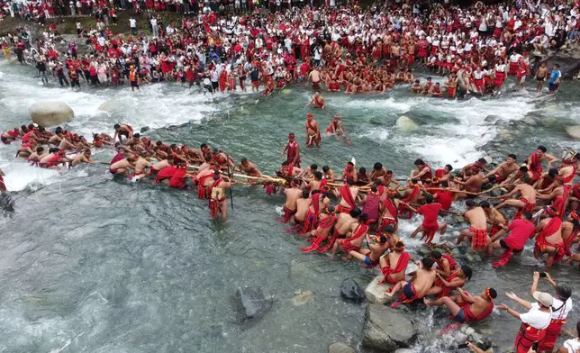 Villagers participate in a tug-of-war as they celebrate the end of the agricultural cycle called "Punnuk" along the Hapao River in Hungduan, Ifugao province, northern Philippines, Saturday Aug. 22, 2026. (AP Photo/Harley Palangchao)