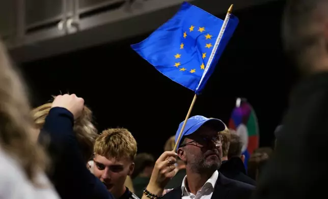 A supporter waves a European Union flag during an election-night gathering for the yes in Reykjavik, Iceland, Sunday, Aug. 30, 2026. (AP Photo/Marco Di Marco)