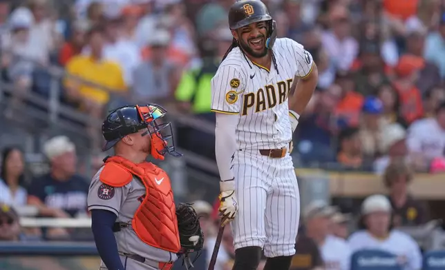 San Diego Padres' Fernando Tatis Jr. jokes with Houston Astros catcher Christian Vázquez during the fourth inning of a baseball game Saturday, Aug. 8, 2026, in San Diego. (AP Photo/Gregory Bull)