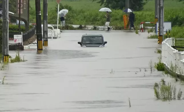 A vehicle is left in a street flooded due to a heavy rain in Himi, Toyama prefecture, Japan Thursday, Aug. 27, 2026. (Suo Takekuma/Kyodo News via AP)