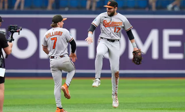 Baltimore Orioles center fielder Colton Cowser (17) and second baseman Jackson Holliday (7) celebrate after the team defeated the Tampa Bay Rays during a baseball game Sunday, Aug. 16, 2026, in St. Petersburg, Fla. (AP Photo/Chris O'Meara)