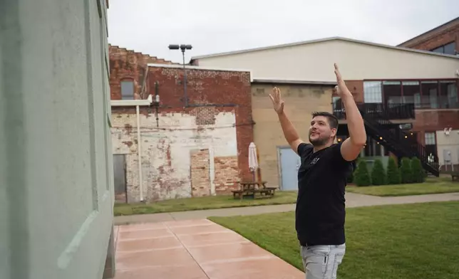 Wesley Mast, owner and president of Coppes Napanee, gestures next to a giant replica of a Hoosier cabinet in Nappanee, Ind., Thursday, Aug. 6, 2026. (AP Photo/Obed Lamy)