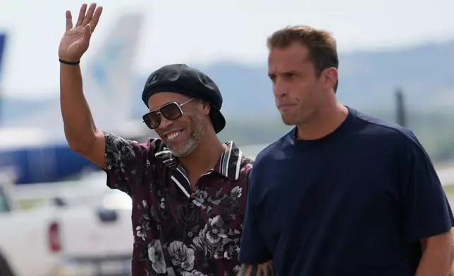 Former soccer star Ronaldinho, flanked by Ravenna president Igniazio Cipriani, right, arrives at the airport ahead the Ravenna Serie C, 2026 soccer team presentation, joining the club as a technical coach and playing in one match in Ravenna, Italy, Thursday, Aug. 20, 2026. (AP Photo/Luca Bruno)