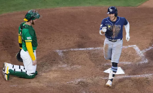 Tampa Bay Rays' Taylor Walls, right, reacts after touching home plate on a solo home run during the sixth inning of a baseball game against the Athletics Tuesday, Aug. 11, 2026, in West Sacramento, Calif. (AP Photo/Scott Marshall)