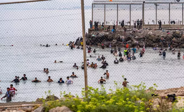 Migrants try to cross from Morocco into the Spanish enclave of Ceuta, Friday, July 31, 2026. (AP Photo/Antonio Sempere)