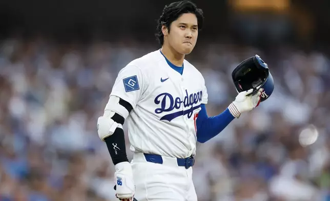 Los Angeles Dodgers designated hitter Shohei Ohtani takes off his batting helmet after receiving a strike during the first inning of a baseball game against the Kansas City Royals, Monday, Aug. 10, 2026, in Los Angeles. (AP Photo/Caroline Brehman)