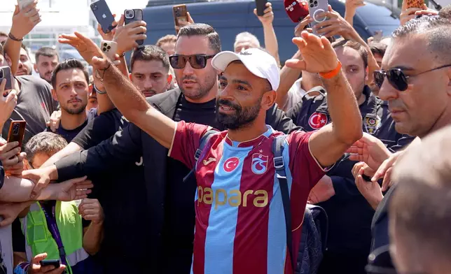 Egypt's Mohamed Salah wearing his new Trabzonspor team jersey gestures to supporters as he arrives at the airport in Istanbul, Turkey, Wednesday, Aug. 5, 2026. (Samet Yalcin/DIA Photo via AP)
