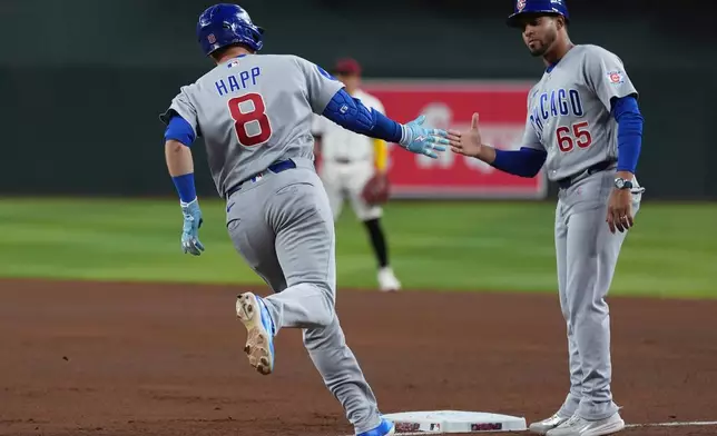 Chicago Cubs' Ian Happ (8) celebrates his three-run home run against the Arizona Diamondbacks with Cubs first base coach Jose Javier (65) during the fourth inning of a baseball game, Tuesday, Aug. 25, 2026, in Phoenix. (AP Photo/Ross D. Franklin)