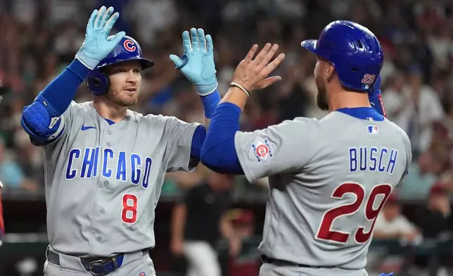 Chicago Cubs' Ian Happ (8) celebrates his three-run home run against the Arizona Diamondbacks with Cubs' Michael Busch (29) during the fourth inning of a baseball game, Tuesday, Aug. 25, 2026, in Phoenix. (AP Photo/Ross D. Franklin)