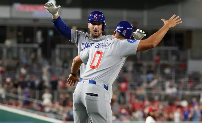 Chicago Cubs' Alex Bregman, left, runs the bases and celebrates his home run with third base coach Quintin Berry (0) hit off of Washington Nationals pitcher Orlando Ribalta during the sixth inning of a baseball game, Tuesday, Aug 11, 2026, in Washington. (AP Photo/Terrance Williams)