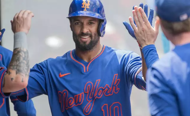 New York Mets' Marcus Semien is congratulated by his teammates after hitting a solo home run off Cleveland Guardians starting pitcher Foster Griffin during the second inning of a baseball game, Thursday, Aug. 6, 2026, in Cleveland. (AP Photo/Phil Long)