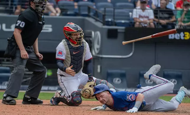 New York Mets' A.J. Ewing hits the deck after dodging an inside pitch from Cleveland Guardians relief pitcher Slade Cecconi as catcher Patrick Bailey and umpire umpire John Bacon look on during the eighth inning of a baseball game, Thursday, Aug. 6, 2026, in Cleveland. (AP Photo/Phil Long)