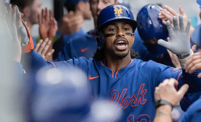 New York Mets' Francisco Lindor is congratulated by his teammates after hitting a three-run home run off Cleveland Guardians relief pitcher Craig Yoho during the seventh inning of a baseball game, Thursday, Aug. 6, 2026, in Cleveland. (AP Photo/Phil Long)