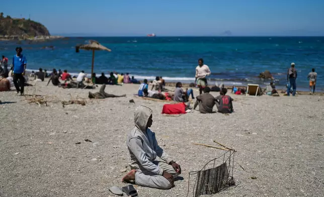 A migrant who crossed into Spain from Morocco prays on a beach in the Spanish enclave of Ceuta, Sunday, Aug. 2, 2026. (AP Photo/Bernat Armangue)
