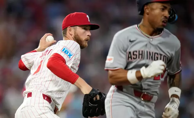 Philadelphia Phillies pitcher Kyle Backhus, left, throws to first after fielding a bunt by Washington Nationals' Nasim Nuñez during the seventh inning of a baseball game Monday, Aug. 3, 2026, in Philadelphia. (AP Photo/Matt Slocum)
