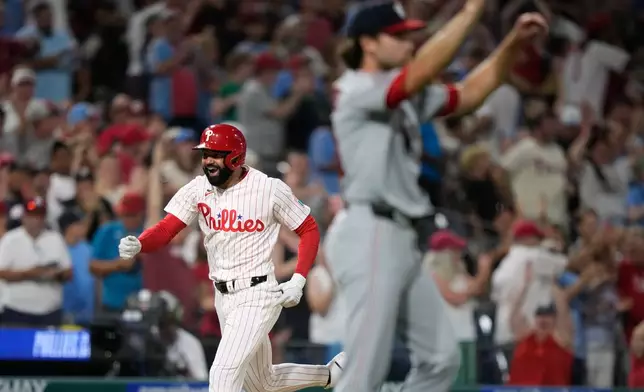 Philadelphia Phillies' Derek Hill, left, reacts after hitting a grand slam against Washington Nationals pitcher Tom Cosgrove during the seventh inning of a baseball game Monday, Aug. 3, 2026, in Philadelphia. (AP Photo/Matt Slocum)