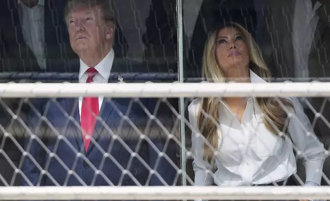 President Donald Trump, left, and first lady Melania Trump attend the IndyCar Freedom 250 Grand Prix auto race, Sunday, Aug. 23, 2026, in Washington. (AP Photo/Julia Demaree Nikhinson)