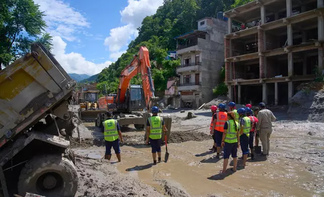 Earthmovers clear the debris from flash flooding in Nepal's Nuwakot district, Thursday, Aug. 27, 2026. (AP Photo/Niranjan Shrestha)