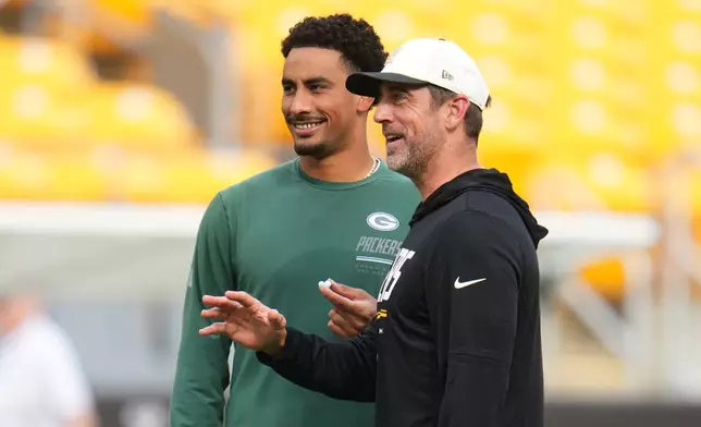Green Bay Packers quarterback Jordan Love, left, talks with Pittsburgh Steelers quarterback Aaron Rodgers, right, during warmups before a preseason NFL football game in Pittsburgh, Thursday, Aug. 13, 2026. (AP Photo/Gene J. Puskar)